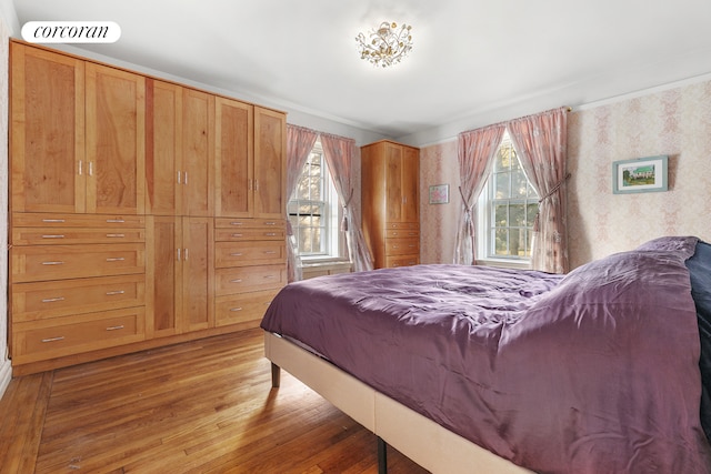 bedroom with wallpapered walls, visible vents, and light wood finished floors