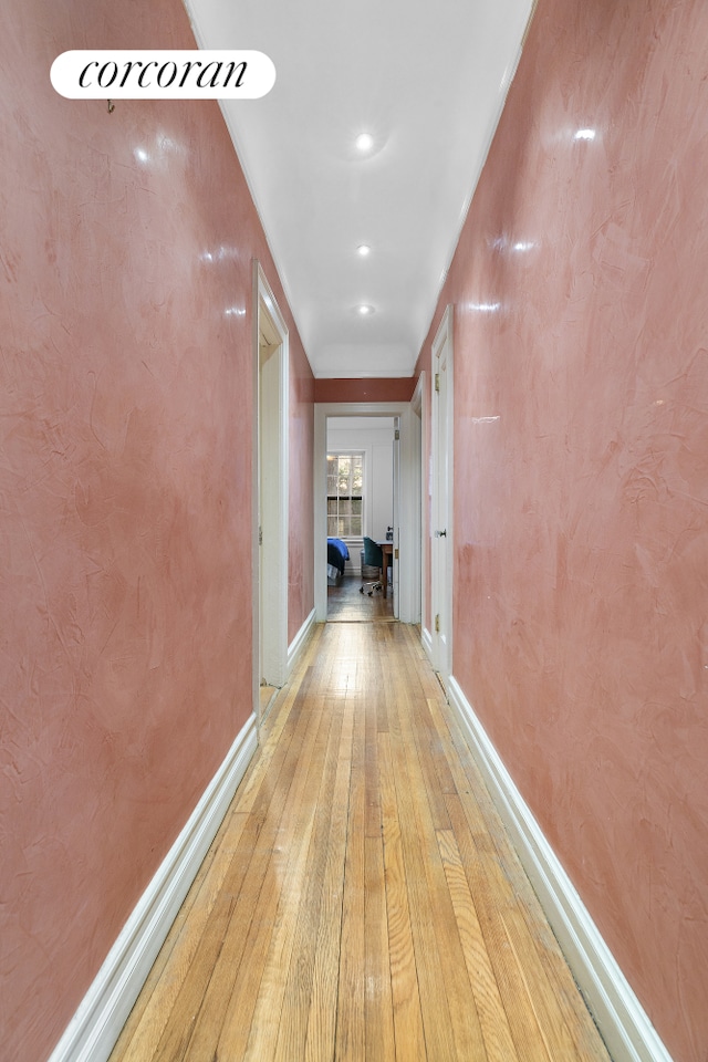 hallway featuring baseboards and light wood-type flooring