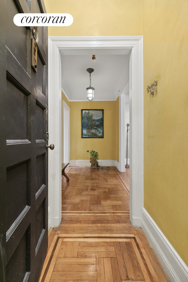 corridor featuring baseboards and ornamental molding