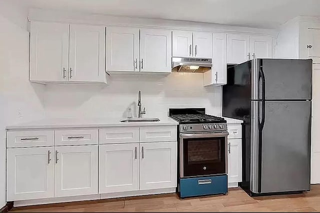 kitchen with sink, white cabinetry, black refrigerator, and stainless steel range with gas stovetop