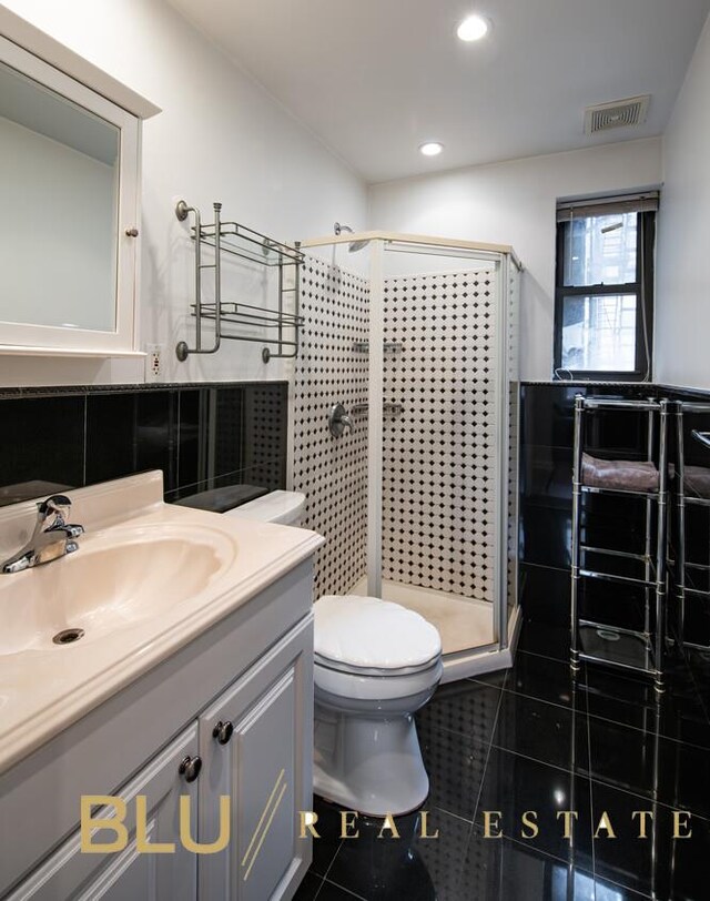 full bathroom featuring tile patterned floors, visible vents, toilet, and a stall shower