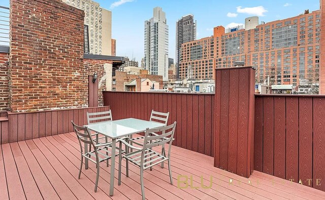 deck featuring a city view and outdoor dining area