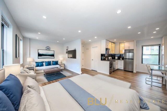 living area with recessed lighting, baseboards, and wood finished floors