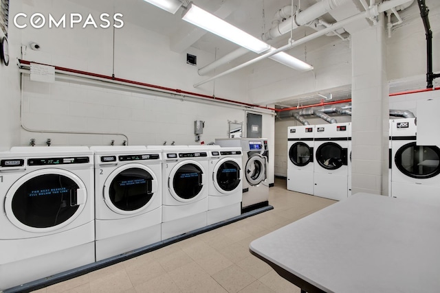 225 E 46th St Unit 12G, New York City, NY 10017 - communal laundry room featuring washing machine and dryer, light flooring, and concrete block wall