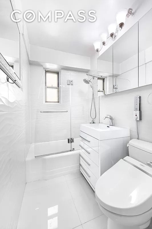 225 E 46th St Unit 12G, New York City, NY 10017 - full bathroom with enclosed tub / shower combo, vanity, and tile patterned floors