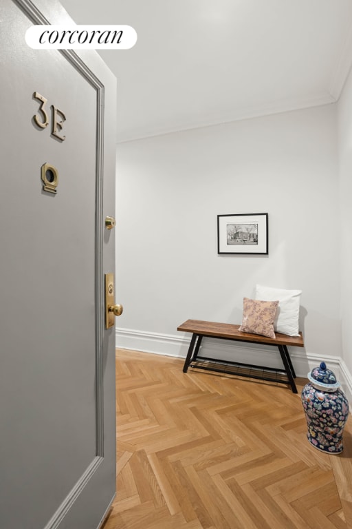 hallway with ornamental molding and baseboards