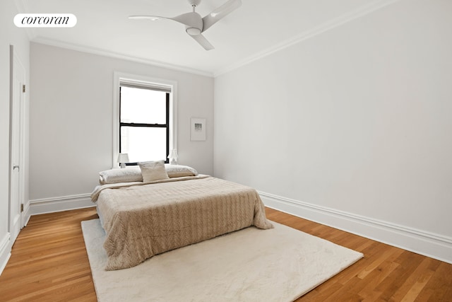 bedroom with baseboards, visible vents, crown molding, and wood finished floors