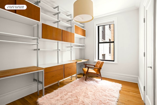 office space with crown molding, wood finished floors, and baseboards