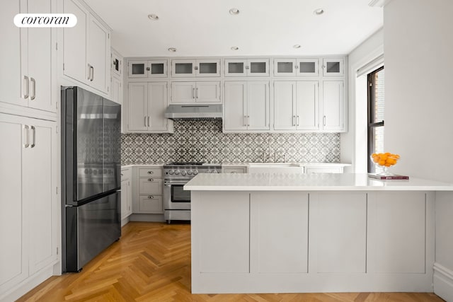 kitchen featuring stainless steel appliances, white cabinets, light countertops, and glass insert cabinets