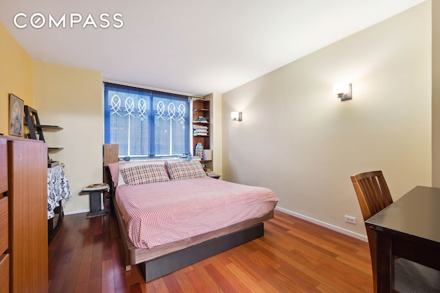 bedroom featuring baseboards and hardwood / wood-style flooring