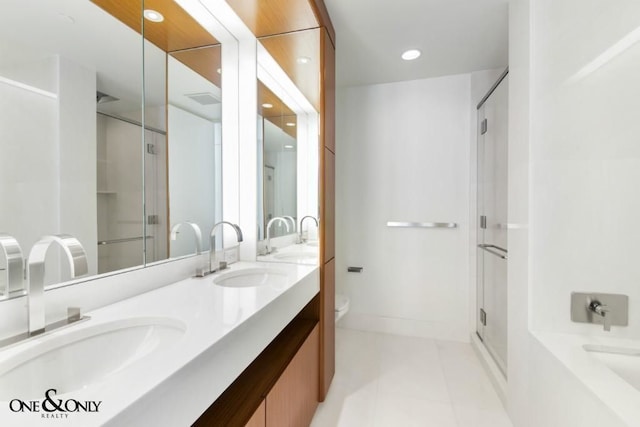 bathroom with tile patterned flooring, vanity, a shower with shower door, and toilet