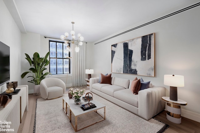 living room with a notable chandelier and light wood-type flooring