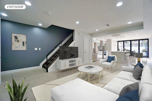 living area with stairs, light wood-style flooring, recessed lighting, and visible vents