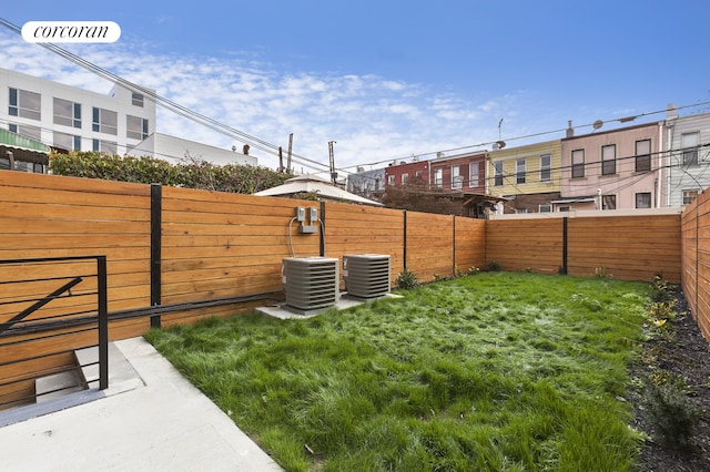 view of yard with central AC unit and a fenced backyard