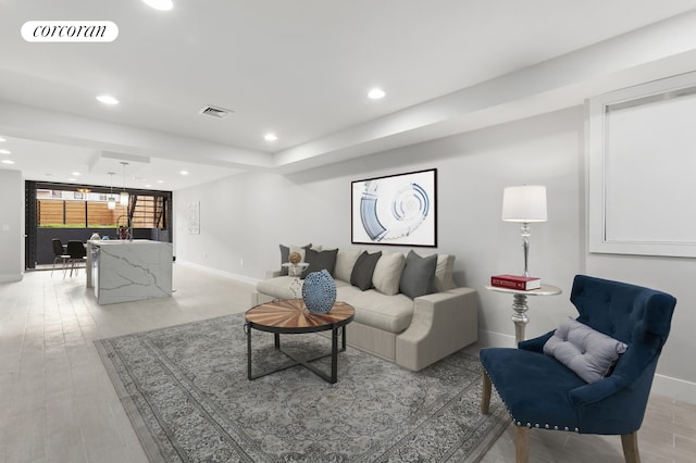 living area with visible vents, recessed lighting, light wood-type flooring, and baseboards