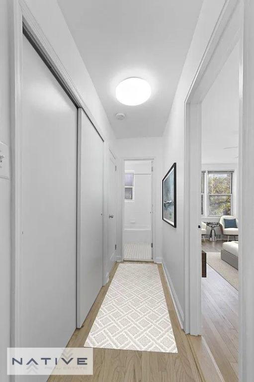 corridor with light hardwood / wood-style floors