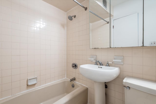 full bathroom featuring visible vents, toilet, shower / tub combination, tile walls, and a sink