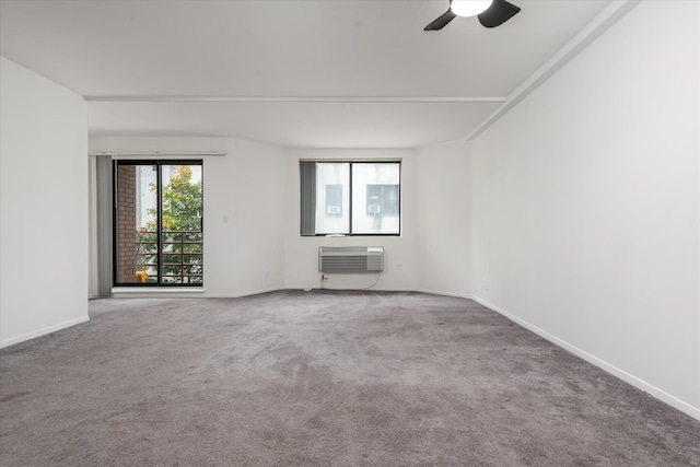 carpeted empty room featuring baseboards, a wall mounted AC, and a ceiling fan