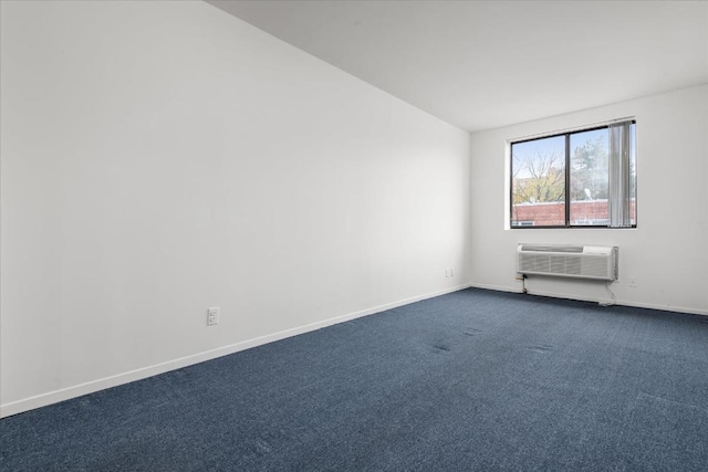 spare room featuring vaulted ceiling, dark colored carpet, and a wall mounted air conditioner