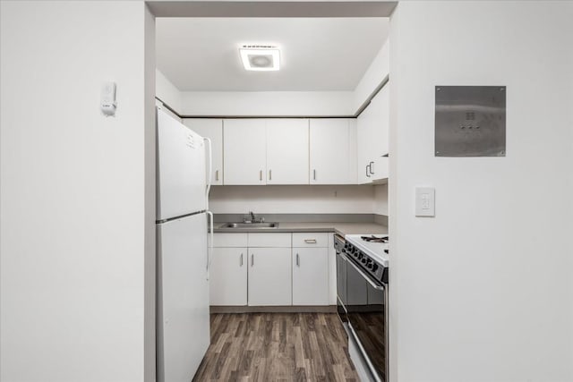 kitchen with a sink, white appliances, dark wood-type flooring, and white cabinetry