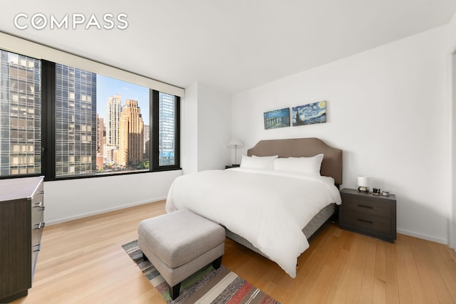 50 United Nations Plz Unit 6C, New York City, NY 10017 - bedroom with light wood-style flooring and a view of skyline