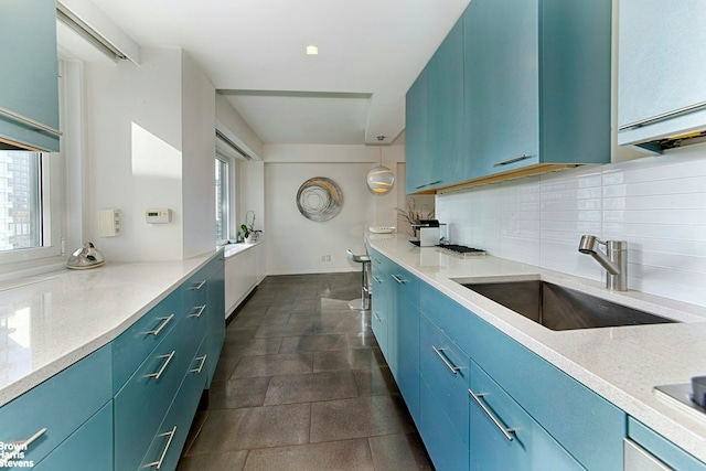 303 E 57th St Unit 46E, New York City, NY 10022 - kitchen with tasteful backsplash, blue cabinetry, and light stone counters