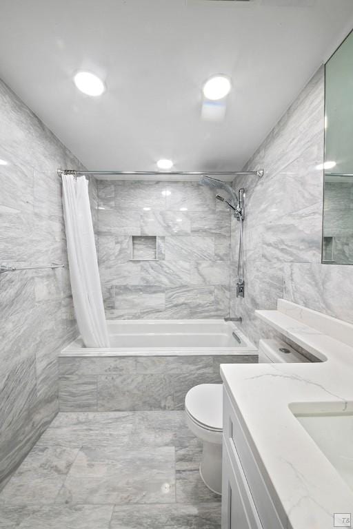 full bathroom featuring vanity, tile walls, toilet, and shower / bath combo