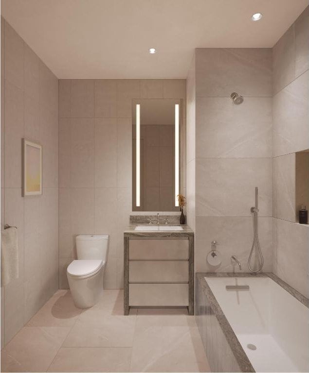 bathroom featuring tile patterned floors, toilet, tile walls, vanity, and a washtub