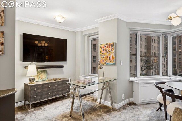 office space with light colored carpet and ornamental molding