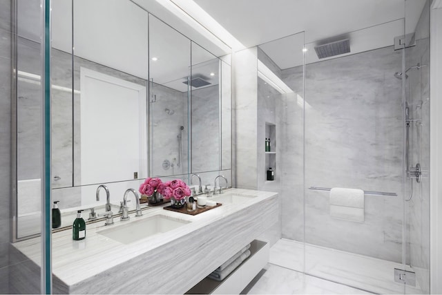 bathroom featuring double vanity, a stall shower, visible vents, and a sink