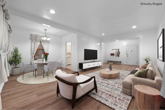 living room featuring a chandelier, recessed lighting, crown molding, and wood finished floors