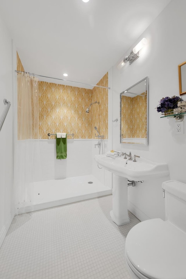 bathroom with tiled shower, tile patterned flooring, and toilet