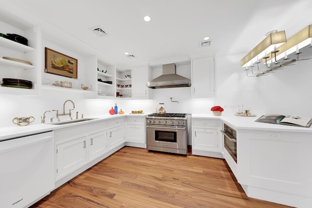 kitchen with a sink, wall chimney range hood, high end stainless steel range, dishwasher, and open shelves