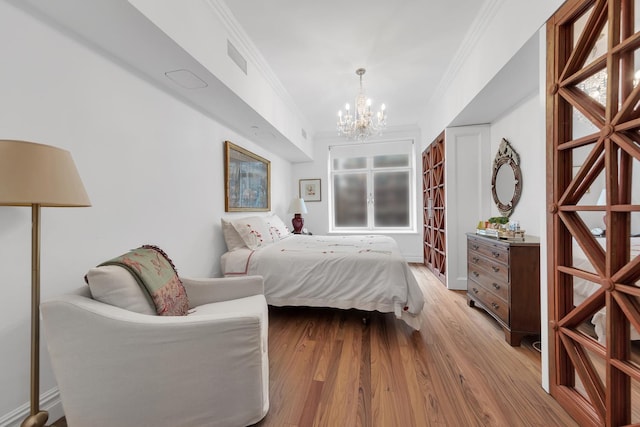 bedroom featuring ornamental molding, wood finished floors, visible vents, and a notable chandelier