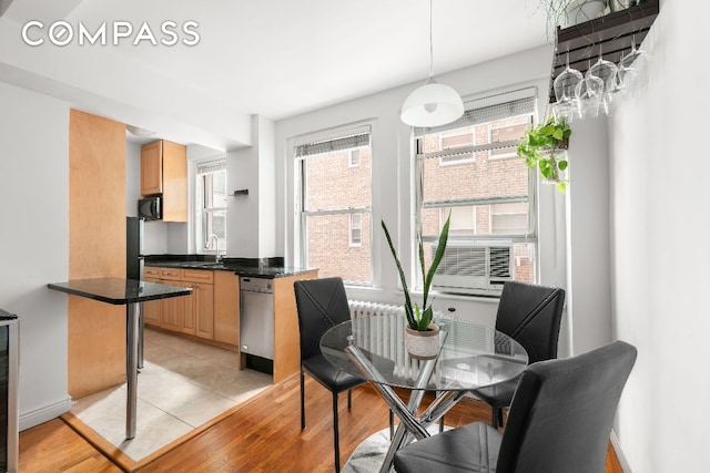 dining area featuring cooling unit and light hardwood / wood-style flooring