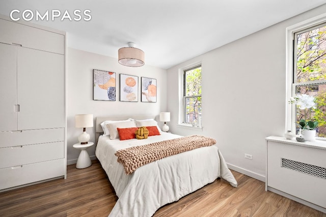 bedroom featuring wood-type flooring and radiator