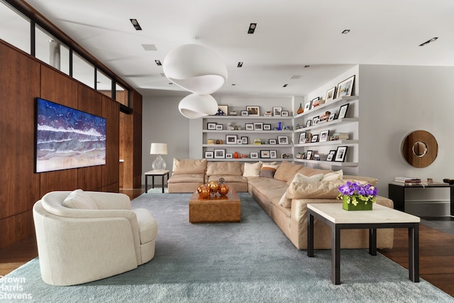 living room with built in shelves and wood finished floors