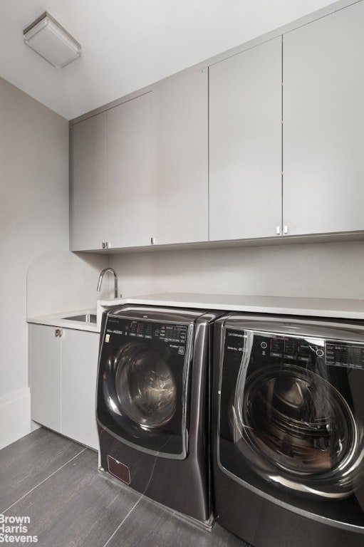 clothes washing area featuring sink, independent washer and dryer, and cabinets