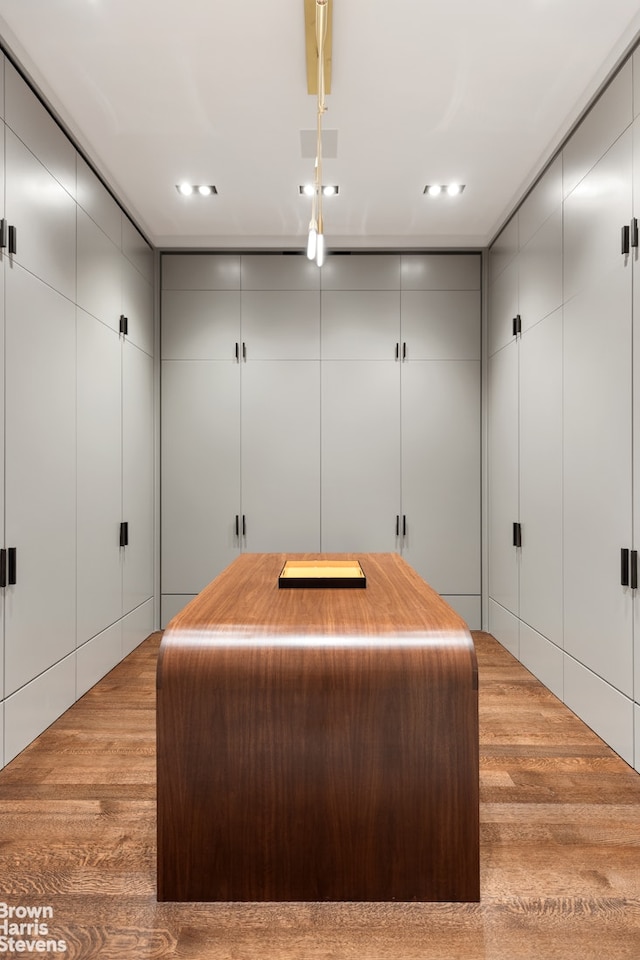 miscellaneous room featuring recessed lighting, wood finished floors, and a decorative wall