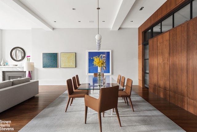 dining area featuring beamed ceiling and dark hardwood / wood-style flooring