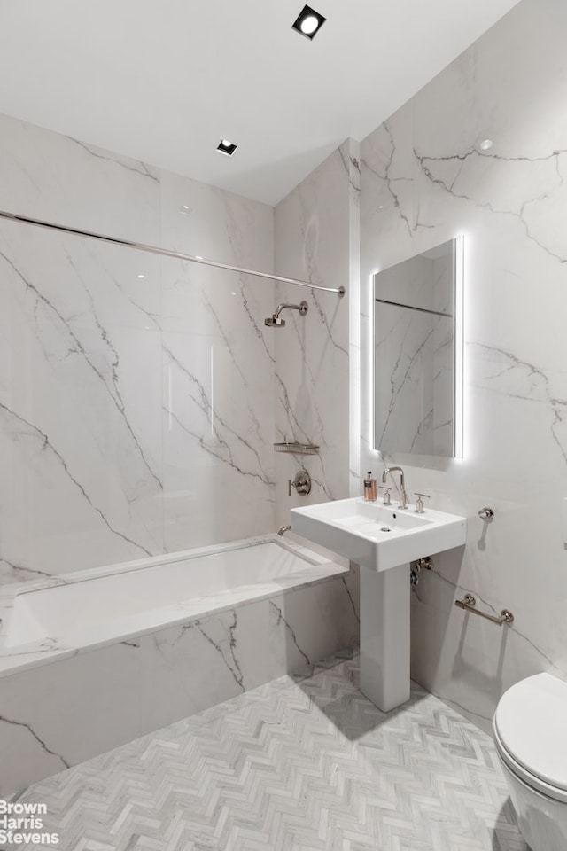 bathroom featuring a combined bath / shower with marble appearance, toilet, and stone wall