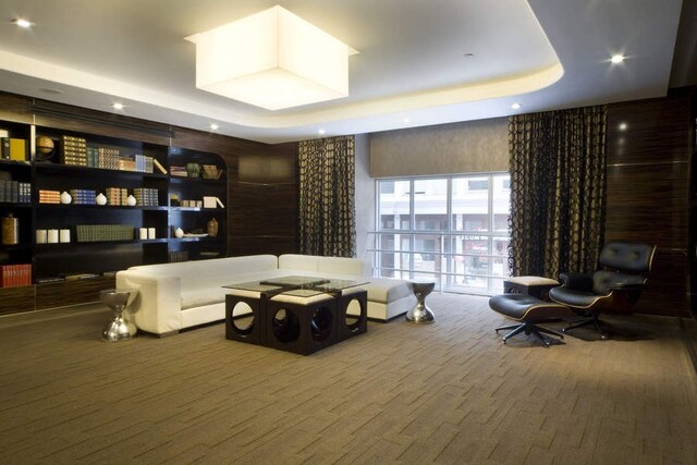 community lobby featuring a tray ceiling and wood-type flooring