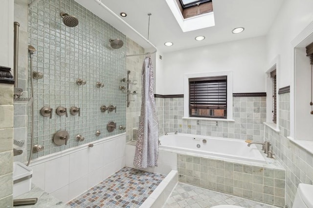 bathroom featuring separate shower and tub, toilet, tile walls, tile patterned floors, and a skylight