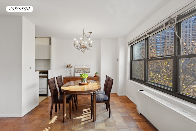 dining area with a chandelier, baseboards, visible vents, and a city view