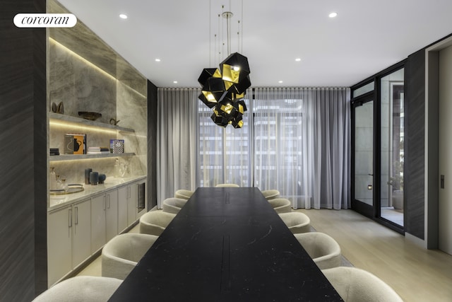 interior space with light stone counters, white cabinets, floor to ceiling windows, open shelves, and decorative light fixtures