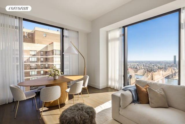 dining area featuring light wood-type flooring, baseboards, and a view of city