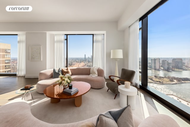 interior space featuring a wealth of natural light, a water view, visible vents, and a city view