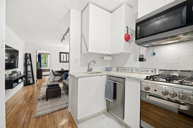 15 Jones St Unit 4D, New York City, NY 10014 - kitchen with stainless steel appliances, white cabinets, modern cabinets, a sink, and tasteful backsplash
