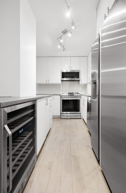 kitchen featuring white cabinetry, appliances with stainless steel finishes, sink, and decorative backsplash