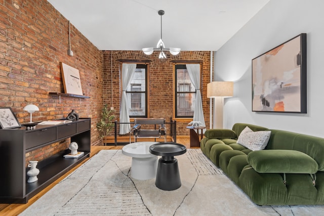 living room featuring brick wall and a chandelier